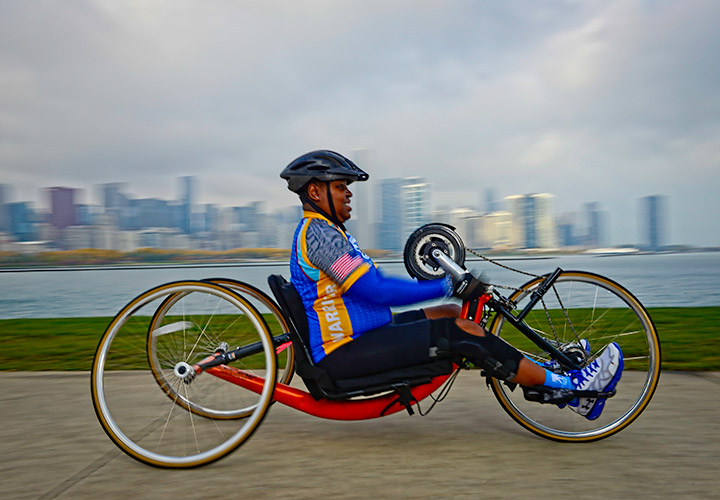 Wounded warrior Donna Pratt cycles on an adaptive bike while wearing Soldier Ride apparel.