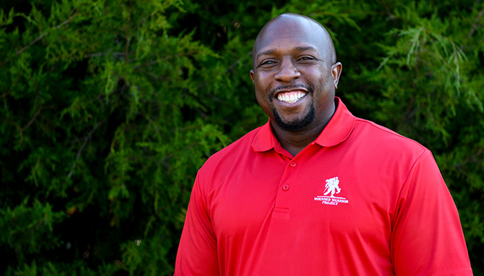 Wounded warrior Melvin Gatewood wearing a red WWP polo and smiling.