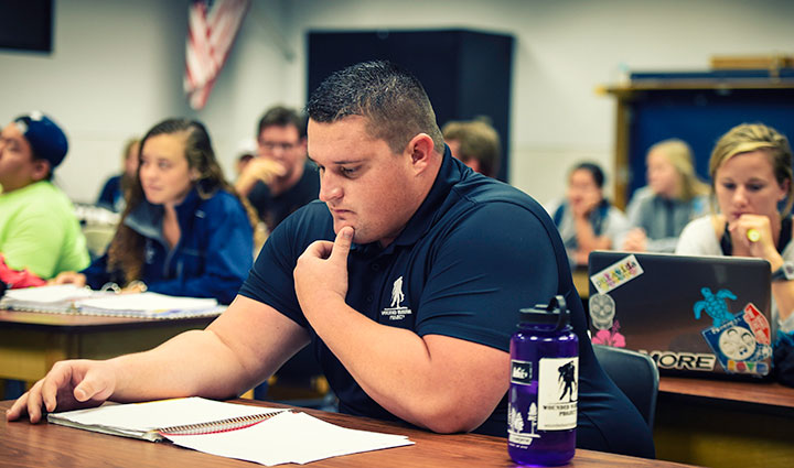 Wounded warrior Brian Wagner sits at a table while looking at a notebook in front of him. 