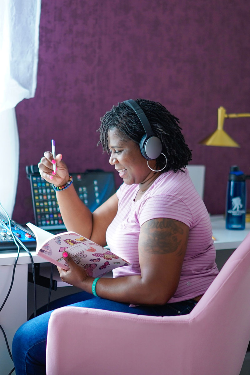 Wounded warrior Taniki Richard sitting in her home office smiling.