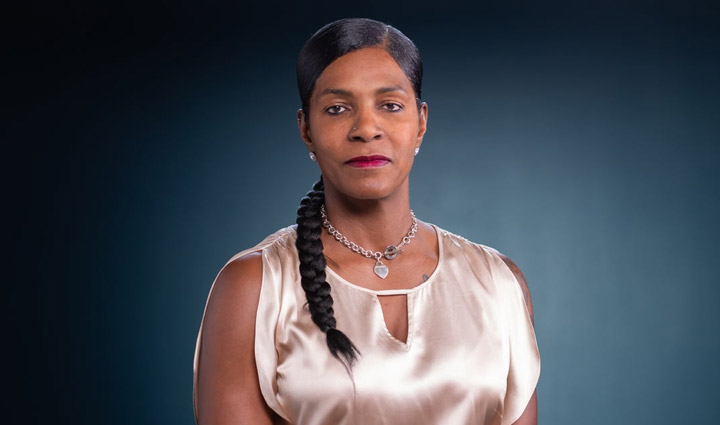 Wounded Warrior Tonya Oxendine sitting in front of a grey background.